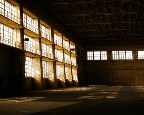 Luce che filtra attraverso le finestre rotte di un magazzino